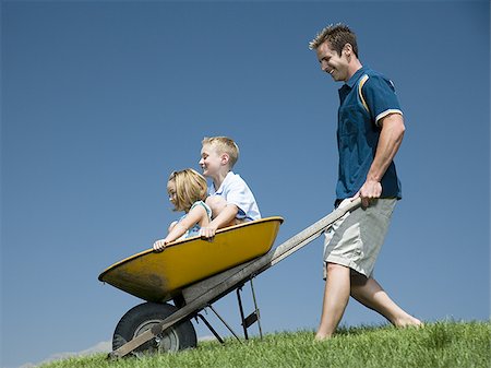 simsearch:640-02769656,k - Father pushing son and daughter in a wheelbarrow Foto de stock - Sin royalties Premium, Código: 640-02769326