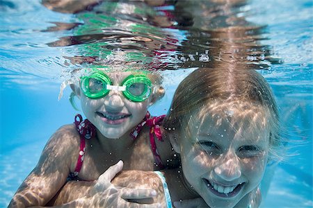 friend playing piggyback - Girls swimming underwater in pool Stock Photo - Premium Royalty-Free, Code: 640-02769537