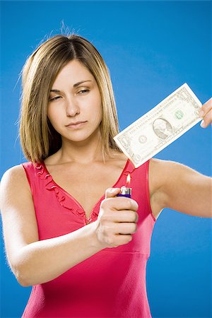 Woman setting American one dollar bill on fire Stock Photo - Premium Royalty-Free, Code: 640-02774000