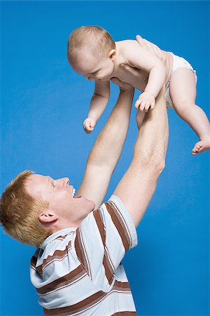 simsearch:640-01458949,k - Bébé holding homme au sourire de l'air Photographie de stock - Premium Libres de Droits, Code: 640-02774106