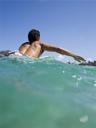 simsearch:640-02773714,k - Man lying on surfboard in water Fotografie stock - Premium Royalty-Free, Codice: 640-02774122