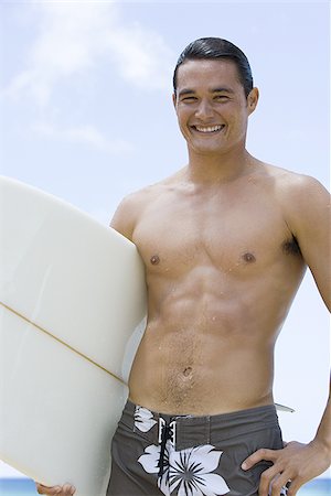 simsearch:640-02773623,k - Homme avec planche de surf sur la plage souriant Photographie de stock - Premium Libres de Droits, Code: 640-02774175