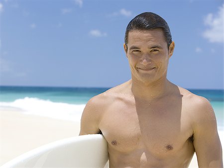simsearch:640-02773623,k - Homme avec planche de surf sur la plage souriant Photographie de stock - Premium Libres de Droits, Code: 640-02774170