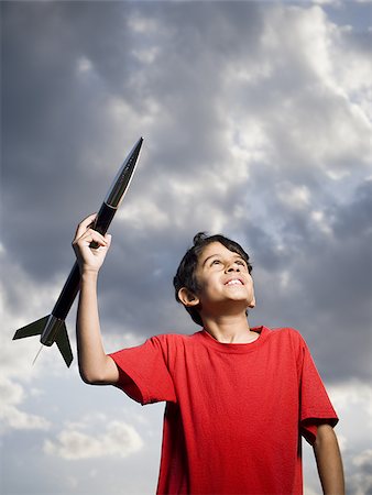 esplorazione spaziale - Boy playing with toy rocket outdoors on cloudy day low angle view Fotografie stock - Premium Royalty-Free, Codice: 640-02774360