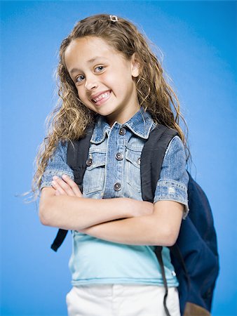 Smiling girl with arms crossed and backpack Stock Photo - Premium Royalty-Free, Code: 640-02774396