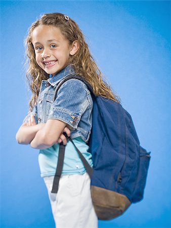 Smiling girl with arms crossed and backpack Stock Photo - Premium Royalty-Free, Code: 640-02774397