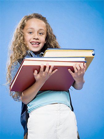 student carrying books - Smiling girl with backpack carrying pile of textbooks Stock Photo - Premium Royalty-Free, Code: 640-02774399