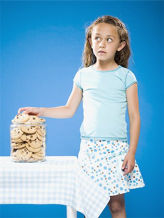 simsearch:640-02765240,k - Girl sneaking Chocolate Chip Cookie from cookie jar Foto de stock - Sin royalties Premium, Código: 640-02774390