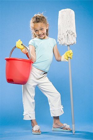 Girl holding mop and bucket with rubber gloves smiling Stock Photo - Premium Royalty-Free, Code: 640-02774409