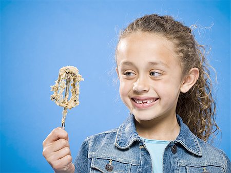 Profile of girl licking batter off beater Stock Photo - Premium Royalty-Free, Code: 640-02774400