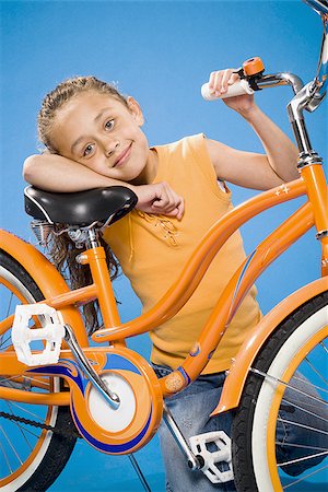 simsearch:640-02765240,k - Girl on orange bicycle smiling Foto de stock - Sin royalties Premium, Código: 640-02774414