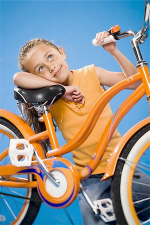 simsearch:640-02765240,k - Girl on orange bicycle smiling Foto de stock - Sin royalties Premium, Código: 640-02774415