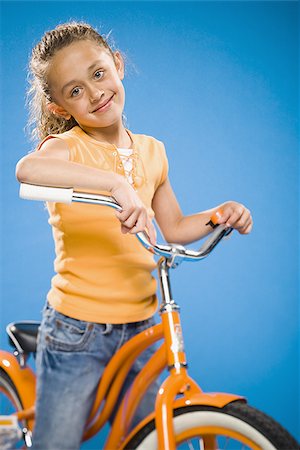 simsearch:640-02765240,k - Girl on orange bicycle smiling Foto de stock - Sin royalties Premium, Código: 640-02774417