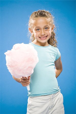 Girl holding cotton candy smiling Stock Photo - Premium Royalty-Free, Code: 640-02774410