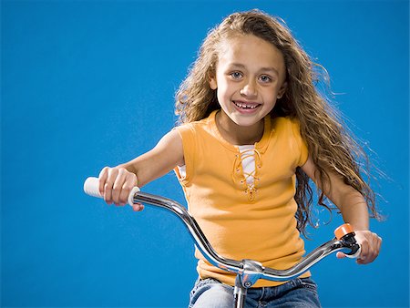 simsearch:640-02765240,k - Girl riding bicycle and smiling Foto de stock - Sin royalties Premium, Código: 640-02774424