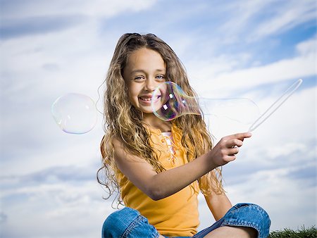 soplando burbujas - Girl outdoors with bubbles smiling Foto de stock - Sin royalties Premium, Código: 640-02774438