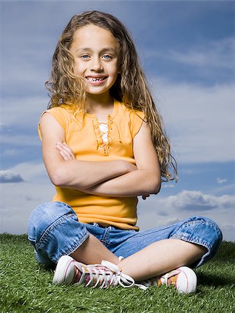 simsearch:640-02765240,k - Girl sitting cross legged on grass outdoors with arms crossed smiling Foto de stock - Sin royalties Premium, Código: 640-02774431