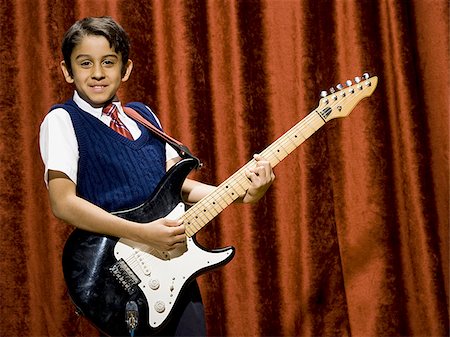 simsearch:640-02772211,k - Boy on stage playing electric guitar Foto de stock - Sin royalties Premium, Código: 640-02774479