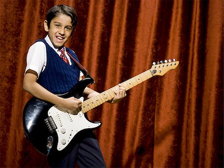 simsearch:640-02772211,k - Boy on stage playing electric guitar Foto de stock - Sin royalties Premium, Código: 640-02774480