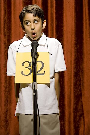 simsearch:640-02774365,k - Boy standing at microphone speaking with number around neck Stock Photo - Premium Royalty-Free, Code: 640-02774504