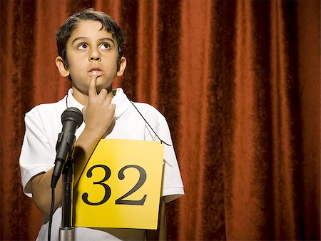 simsearch:640-02774524,k - Candidat garçon debout à la pensée de microphone Photographie de stock - Premium Libres de Droits, Code: 640-02774512