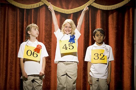 podium sport awards - Three children on stage at winner's podium with ribbons smiling Stock Photo - Premium Royalty-Free, Code: 640-02774548