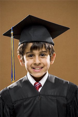 school kids graduate - Boy graduate with mortar board smiling with arms crossed Stock Photo - Premium Royalty-Free, Code: 640-02774615