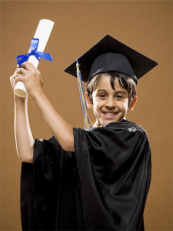 Boy graduate with mortar board and diploma smiling Foto de stock - Royalty Free Premium, Número: 640-02774616