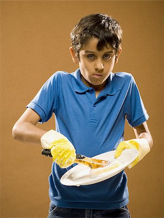simsearch:640-02774365,k - Boy with rubber gloves scrubbing plate Stock Photo - Premium Royalty-Free, Code: 640-02774639