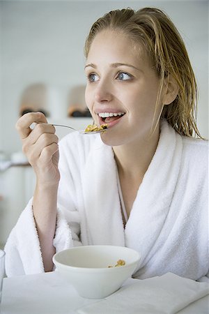 Woman in bathrobe eating cereal Stock Photo - Premium Royalty-Free, Code: 640-02774669