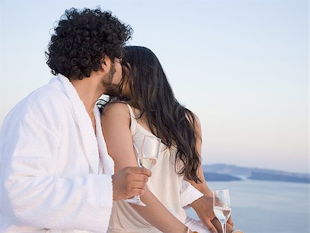 Couple kissing outdoors with champagne flutes Stock Photo - Premium Royalty-Free, Code: 640-02774697