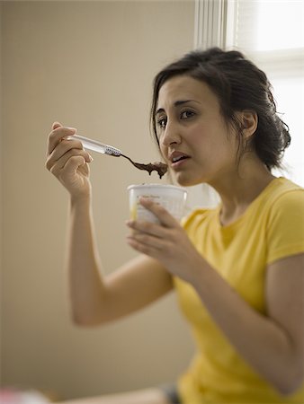 sadness and icecream - Woman sitting and eating ice cream Stock Photo - Premium Royalty-Free, Code: 640-02774736