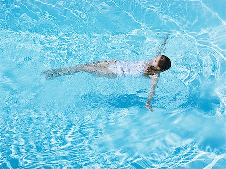 Woman floating in pool Stock Photo - Premium Royalty-Free, Code: 640-02774976