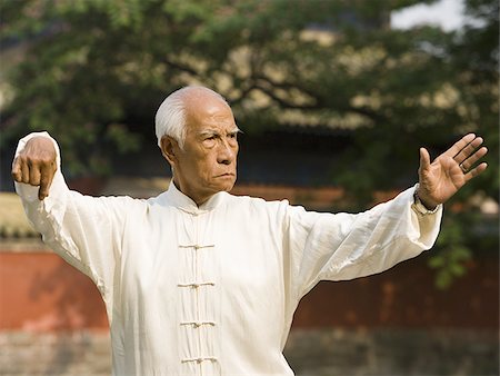 Man doing Kung Fu outdoors with pagoda in background Stock Photo - Premium Royalty-Free, Code: 640-02775064