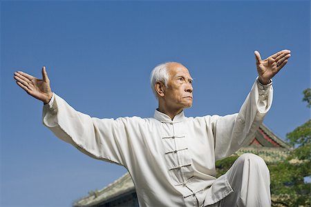 Man doing Kung Fu outdoors with pagoda in background Stock Photo - Premium Royalty-Free, Code: 640-02775061