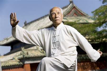 Man doing Kung Fu outdoors with pagoda in background Stock Photo - Premium Royalty-Free, Code: 640-02775062