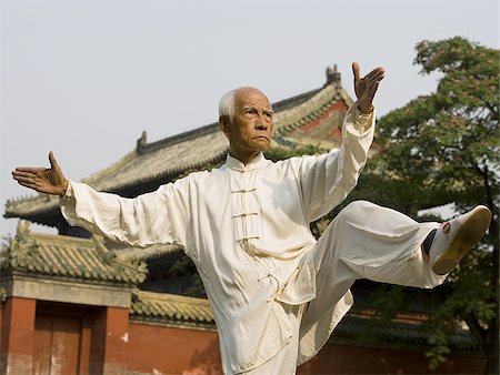 Man doing Kung Fu outdoors with pagoda in background Stock Photo - Premium Royalty-Free, Code: 640-02775063