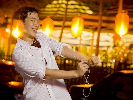 Man with mp3 player dancing and smiling outdoors Stock Photo - Premium Royalty-Free, Code: 640-02775074