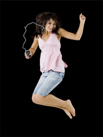 Femme avec lecteur mp3 sautant et souriant Photographie de stock - Premium Libres de Droits, Code: 640-02775217