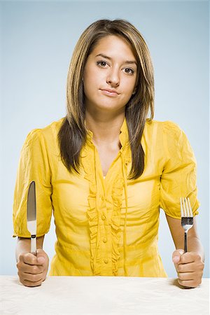 Woman with fork and knife in fists Stock Photo - Premium Royalty-Free, Code: 640-02775249
