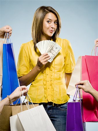 Woman with shopping bags and large sum of cash smiling Foto de stock - Royalty Free Premium, Número: 640-02775257