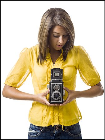 Woman holding old fashioned camera smiling Stock Photo - Premium Royalty-Free, Code: 640-02775258