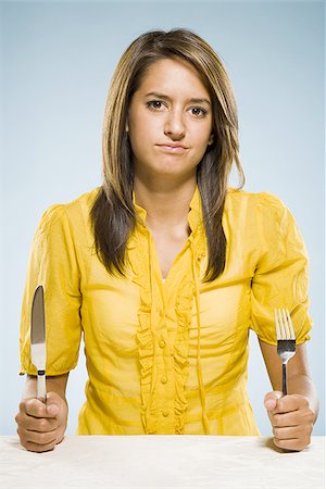 simsearch:640-02775683,k - Femme avec fourchette et couteau à poings Photographie de stock - Premium Libres de Droits, Code: 640-02775250