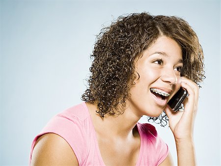 simsearch:640-01601405,k - Girl with braces talking on cell phone smiling Foto de stock - Royalty Free Premium, Número: 640-02775290