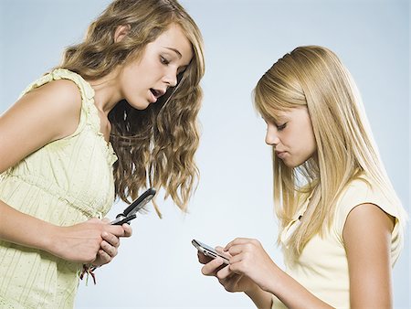 simsearch:640-01601405,k - Two girls with cell phones smiling Foto de stock - Royalty Free Premium, Número: 640-02775309