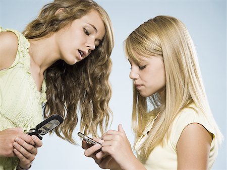 simsearch:640-01601405,k - Two girls with cell phones smiling Foto de stock - Royalty Free Premium, Número: 640-02775310