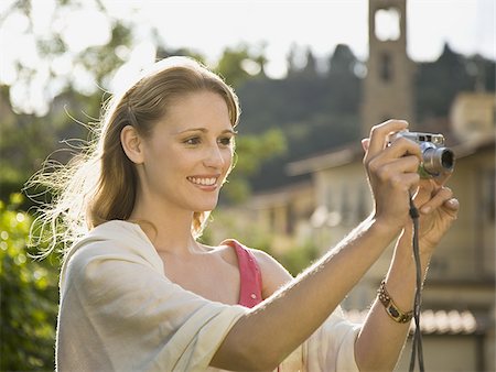 simsearch:640-01601608,k - Woman smiling and taking a photograph outdoors Stock Photo - Premium Royalty-Free, Code: 640-02775402