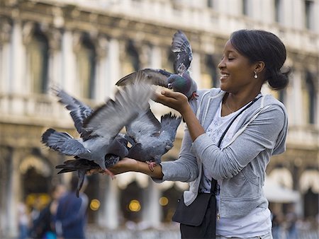 simsearch:640-01601762,k - Femme sur une place publique avec des pigeons souriant Photographie de stock - Premium Libres de Droits, Code: 640-02775445
