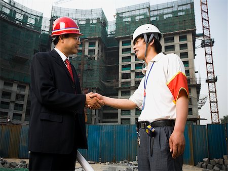 Construction foreman and worker outdoors shaking hands Stock Photo - Premium Royalty-Free, Code: 640-02775467