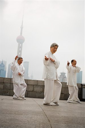 simsearch:640-02775784,k - Groupe faire tai chi en plein air avec des toits de la ville en arrière-plan Photographie de stock - Premium Libres de Droits, Code: 640-02775586